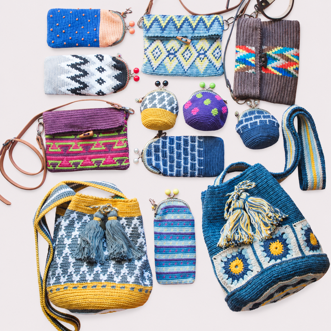 Colección de bolsos, monederos y fundas de crochet hechos a mano por MarviCrochet sobre fondo blanco roto.